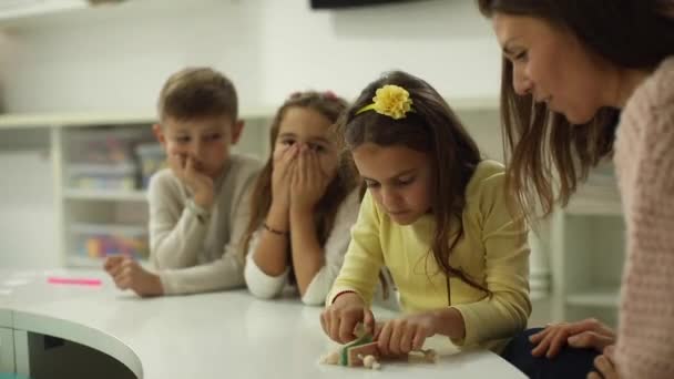 Profesor Jardín Infantes Explicando Los Niños Cómo Jugar Con Juguetes — Vídeos de Stock