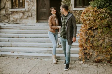 Güz parkında yürüyen yakışıklı genç çift.