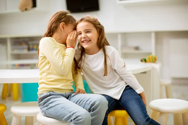 Cute Little Girl Szepcząc Coś Ucha Jej Przyjaciela — Zdjęcie stockowe