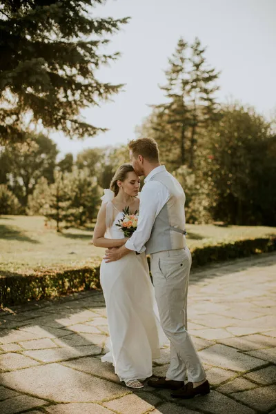 かわいい若い新婚夫婦が公園に立っている — ストック写真