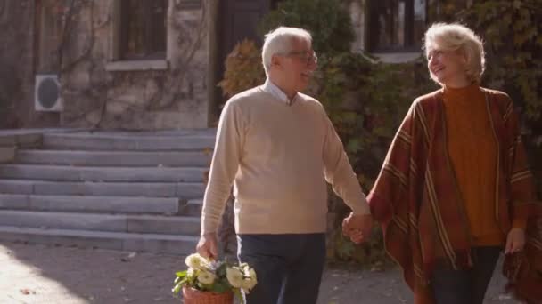 Pasangan Senior Yang Tampan Berjalan Dengan Keranjang Penuh Bunga Dan — Stok Video