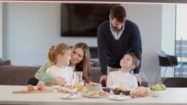 Genç mutlu aile, evdeki yemek masasında kahvaltı ederken konuşuyor.