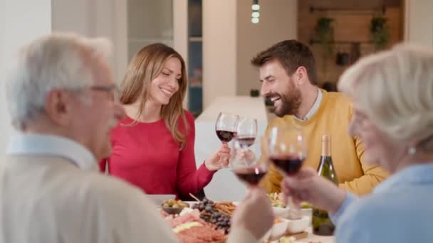 Šťastná rodina večeří s červeným vínem doma