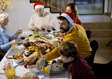 Mutlu çok nesilli aile yeni yılı evde, masada kutluyor.