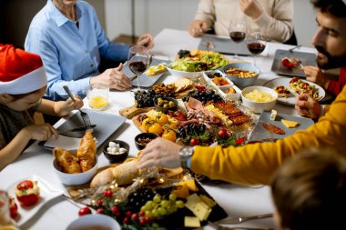 Mutlu çok nesilli aile, yeni yılı evdeki yemek dolu masada kutluyor.
