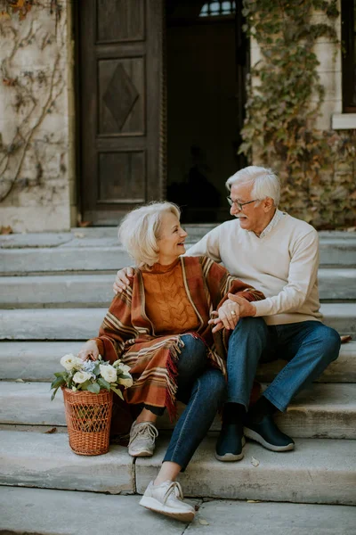 Όμορφο Ζευγάρι Ηλικιωμένων Κάθεται Στις Σκάλες Καλάθι Γεμάτο Λουλούδια Και — Φωτογραφία Αρχείου