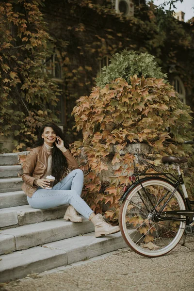 Красивая Молодая Женщина Мобильным Телефоном Пьет Кофе Пойти Лестнице Велосипеде — стоковое фото