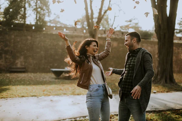 Mutlu Genç Çift Parkta Sonbahar Yapraklarıyla Eğleniyor — Stok fotoğraf