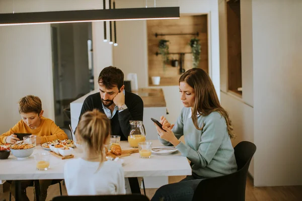 Familia Usando Teléfonos Móviles Mientras Desayuna Mesa Comedor Del Apartamento — Foto de Stock