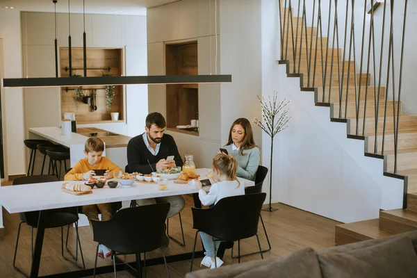Família Usando Telefones Celulares Enquanto Toma Café Manhã Mesa Jantar — Fotografia de Stock