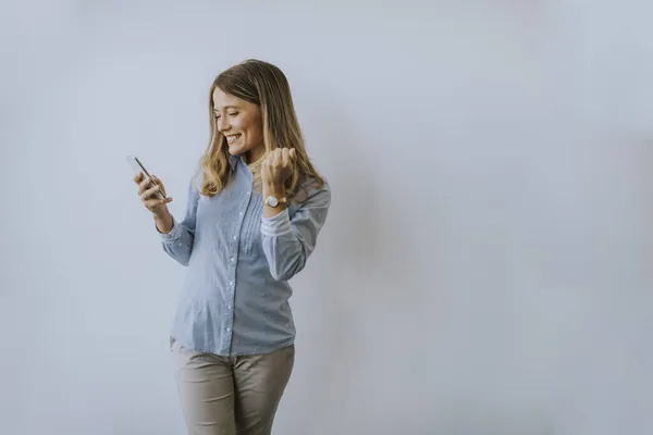 Jonge Zakenvrouw Met Behulp Van Mobiele Telefoon Aan Muur Het — Stockfoto