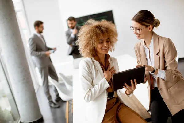 Dos Jóvenes Empresarias Discutiendo Con Tableta Digital Oficina Con Jóvenes — Foto de Stock