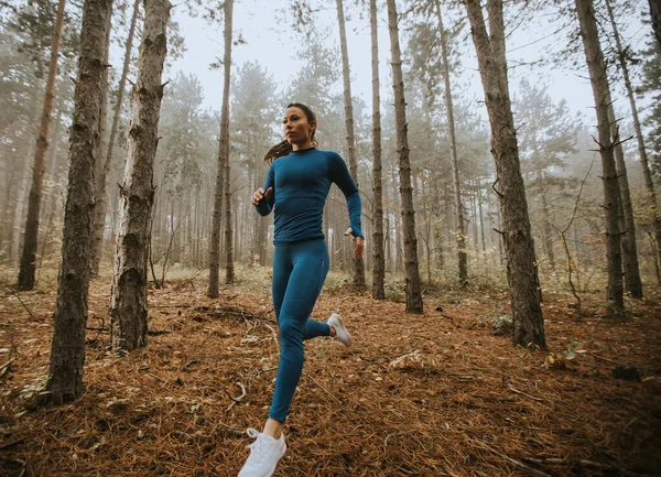 Młoda Kobieta Niebieskim Dresie Biegnie Jesienią Kierunku Kamery Leśnym Szlaku — Zdjęcie stockowe