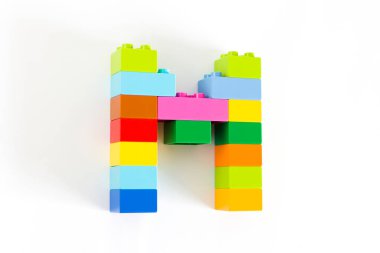 Beyaz arkaplanda M harfi izole edilmiş renkli oyuncak.