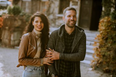 Güz parkında yürüyen yakışıklı genç çift.