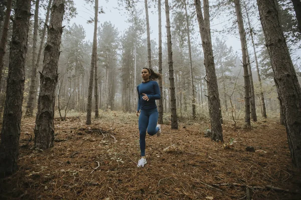 Junge Frau Blauen Trainingsanzug Läuft Herbst Auf Dem Waldweg Auf — Stockfoto