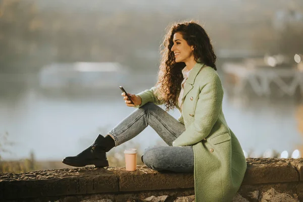 Mooie Jonge Krullend Haar Vrouw Met Behulp Van Smartphone Tijdens — Stockfoto