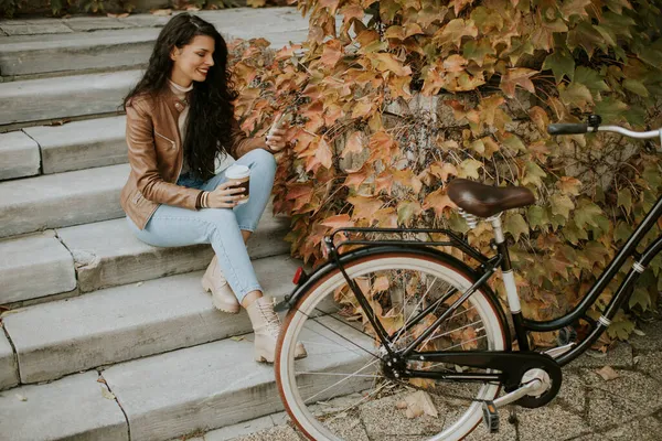 Красивая Молодая Женщина Мобильным Телефоном Пьет Кофе Пойти Лестнице Велосипеде — стоковое фото