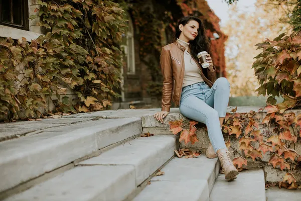 여자가 가을에 계단에서 테이크 커피를 마시는 — 스톡 사진