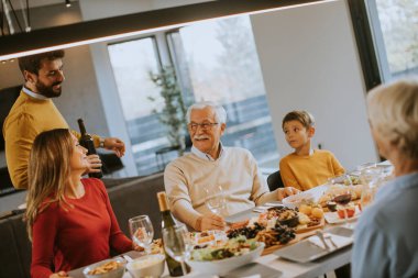 Yakışıklı genç adam evde test için babasına kırmızı şarap veriyor.
