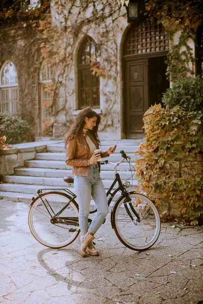 Красивая Молодая Женщина Мобильным Телефоном Пьет Кофе Поехать Велосипеде Осенью — стоковое фото