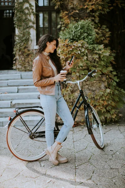 งสาวสวยท โทรศ มกาแฟเพ อไปข กรยานในว นฤด ใบไม — ภาพถ่ายสต็อก