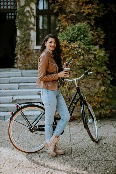 Hübsche Junge Frau Mit Handy Trinkt Herbsttagen Kaffee Zum Fahrradfahren — Stockfoto