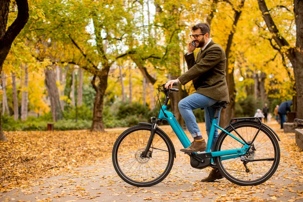 Joven Guapo Usando Teléfono Móvil Bicicleta Eléctrica Parque Otoño — Foto de Stock