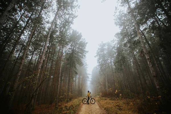 秋の森をサイクリング中にブレーキを踏むハンサムな若い男 — ストック写真