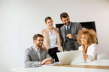 Genç iş adamları toplantı masasında oturmuş iş ve planlama stratejilerini tartışıyorlar.