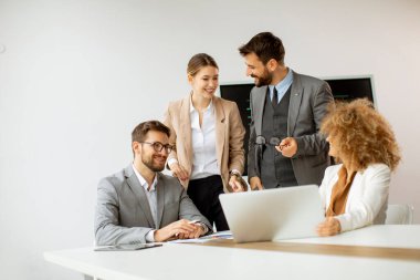 Genç iş adamları toplantı masasında oturmuş iş ve planlama stratejilerini tartışıyorlar.