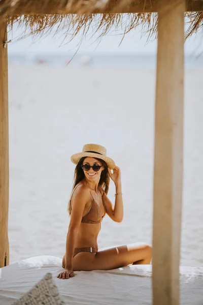 漂亮的年轻女人 戴着帽子和太阳镜 在海滩休息室休息 — 图库照片