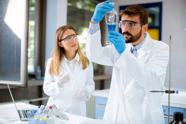 Knappe Jonge Onderzoeker Werkt Met Blauwe Vloeistof Laboratoriumglas Het Lab — Stockfoto