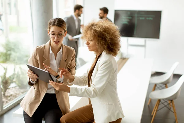 Dos Mujeres Jóvenes Sosteniendo Tableta Digital Trabajando Oficina Moderna —  Fotos de Stock