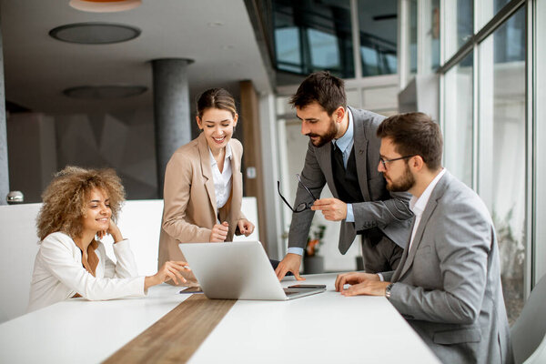 Young business people sitting at meeting table in conference room discussing work and planning strategy