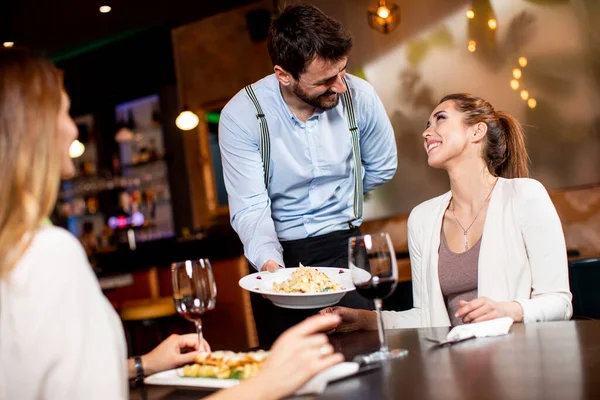 Красивий Молодий Офіціант Який Подає Їжу Жінок Клієнтів Ресторані — стокове фото