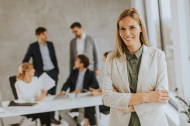 Ofiste ekibinin önünde duran genç ve güzel bir iş kadını.