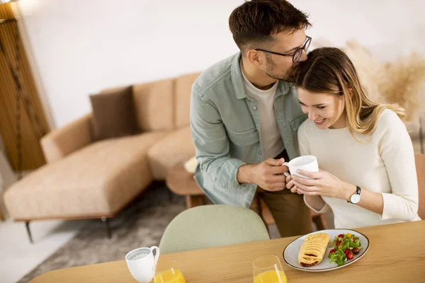 美しい若いカップルが話して笑顔で家で健康的な食事をしながら — ストック写真