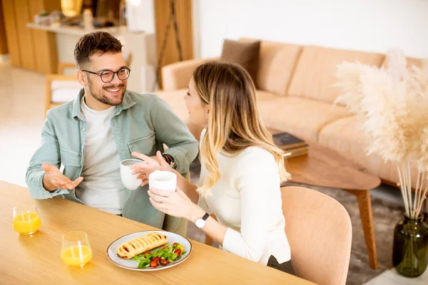 美しい若いカップルが話して笑顔で家で健康的な食事をしながら — ストック写真