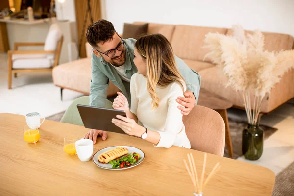 Encantador Jovem Casal Usando Tablet Digital Tomando Café Manhã Cozinha — Fotografia de Stock