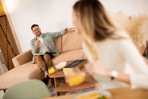 Giovane Donna Che Colazione Cucina Con Fidanzato Seduto Sullo Sfondo — Foto Stock