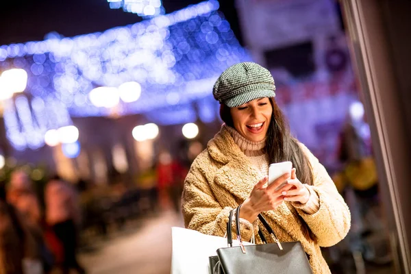 Mulher Bonita Com Telefone Celular Pela Janela Loja Época Natal — Fotografia de Stock