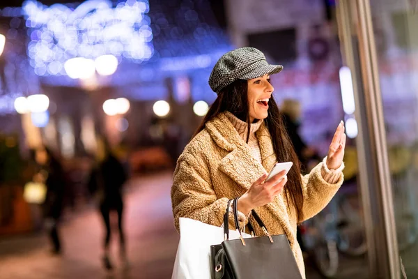 Mulher Bonita Com Telefone Celular Pela Janela Loja Época Natal — Fotografia de Stock