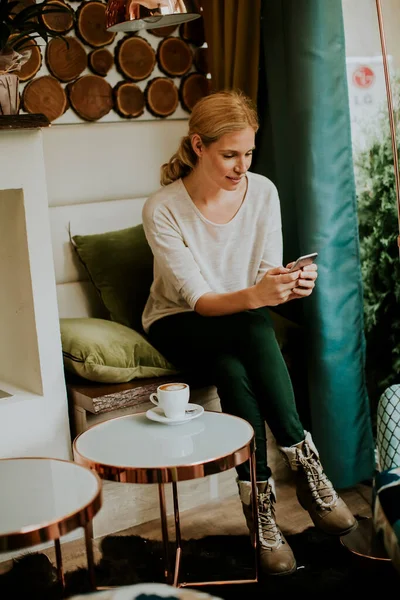 Hezká Mladá Žena Sedí Stolu Kávou Nebo Cappuccino Pomocí Mobilního — Stock fotografie