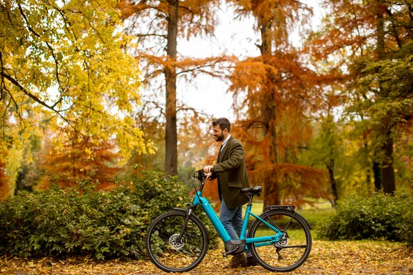 Przystojny Młody Człowiek Rowerem Elektrycznym Jesiennym Parku — Zdjęcie stockowe