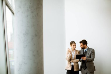 Modern ofisin duvarında dijital tabletli gençler