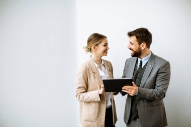 Modern ofisin duvarında dijital tabletli gençler