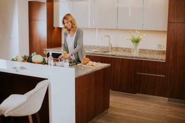 Genç bayan mutfakta spagetti hazırlıyor.