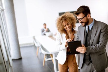 Genç çoklu etnik girişimciler modern ofiste bir araya gelip konuşuyorlar.