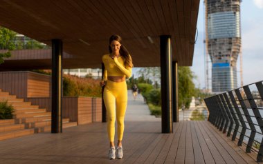 Nehir kenarındaki iskelede egzersiz yapan güzel genç bir kadın.